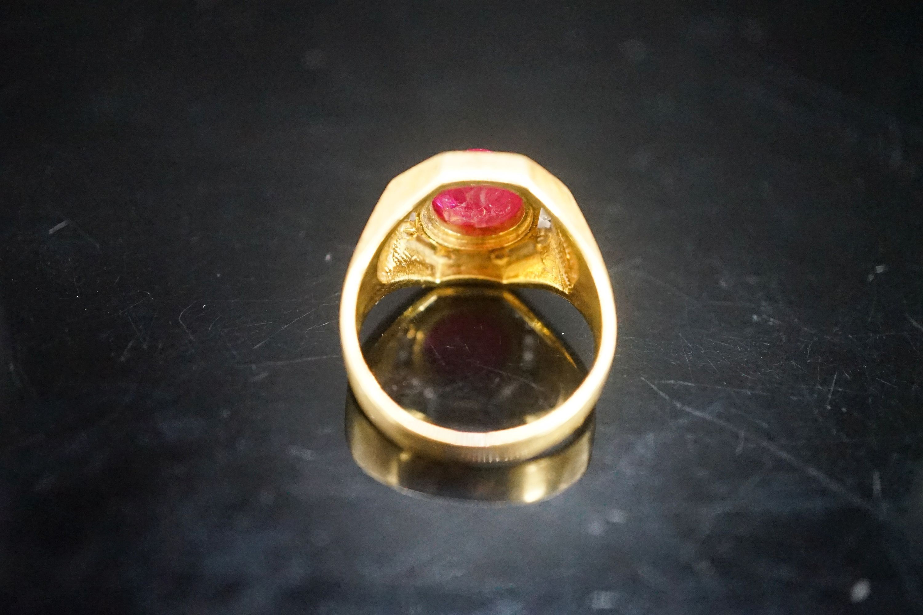 A modern continental yellow metal, cabochon ruby and diamond cluster set octagonal dress ring, size Q, gross weight 9.9 grams.